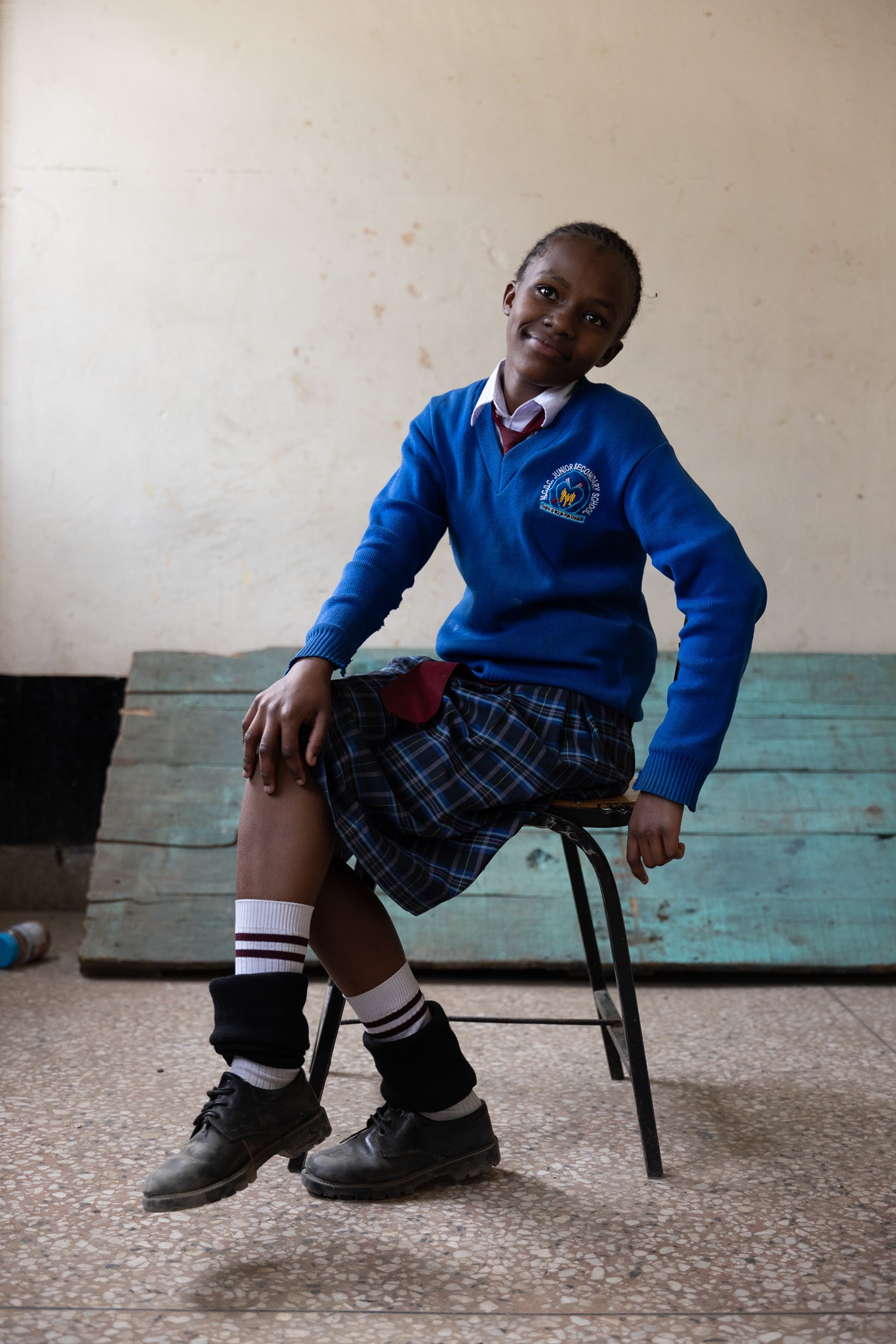 Student in blue school uniform seated, relaxed and confident