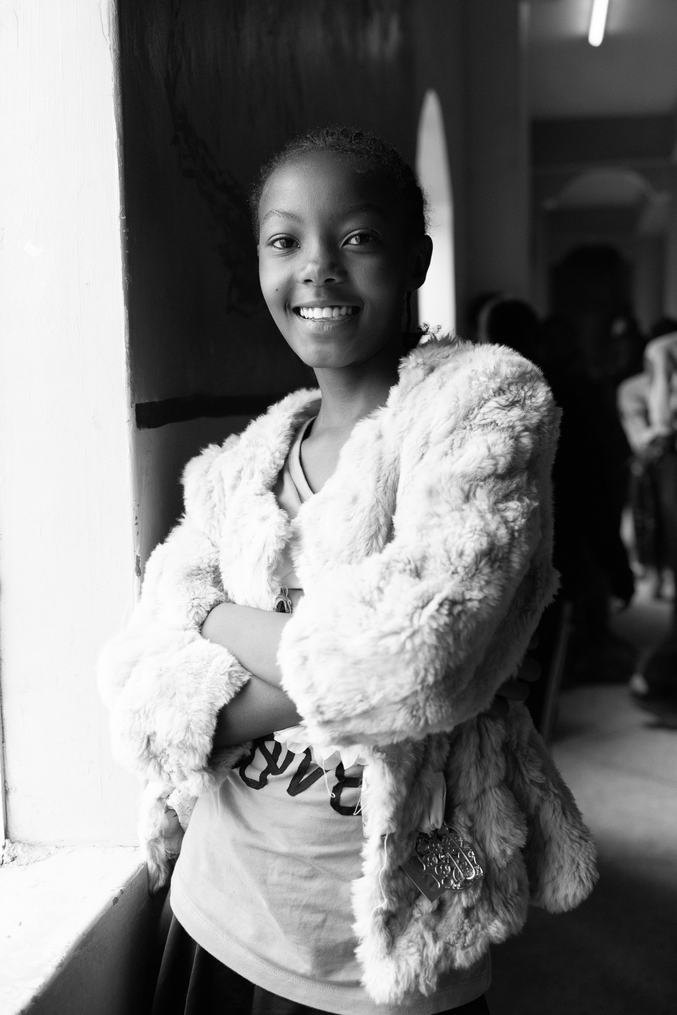 Young model in black and white, arms crossed, smiling